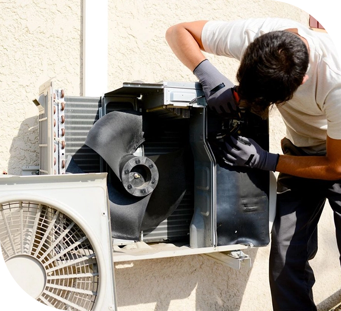 A man working on an air conditioner unit.