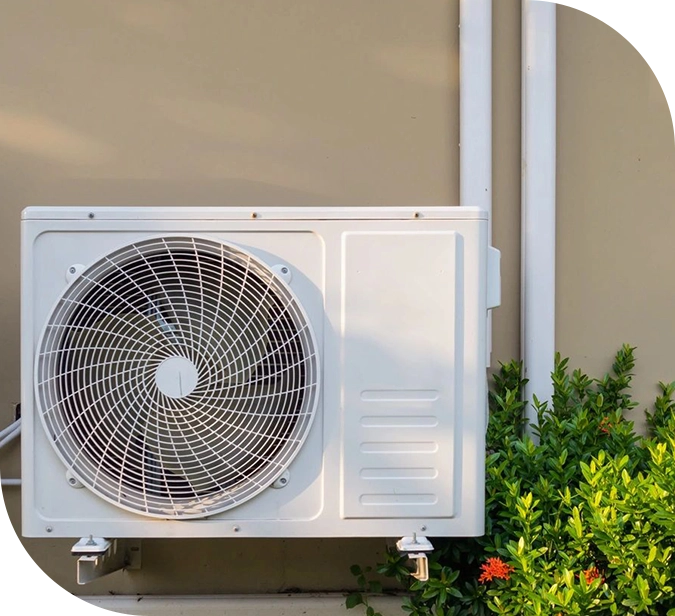 A white air conditioner mounted to the side of a building.